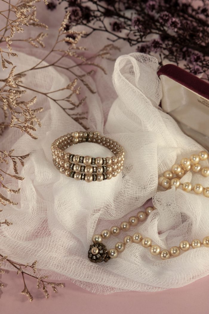 Elegant close-up of pearl jewelry arranged on delicate fabric, perfect for fashion and lifestyle themes.